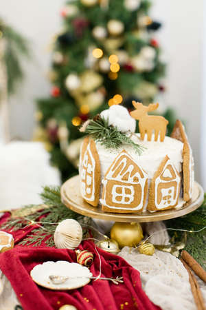 Christmas cake with gingerbread cookies near Christmas treeの写真素材