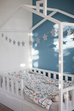 House shaped bed in childs room with blue and white wallsの写真素材