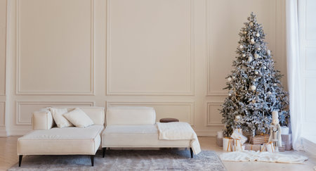 Modern interior with white big sofa and Christmas tree with lights and decorations near big windowの写真素材