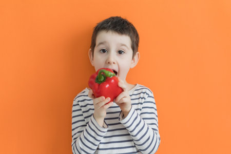 Child holds eco bag with fresh vegetables from farm market on an orange background with copy space. Healthy food concept, fresh vegetables, farm marketの写真素材
