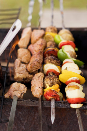 Skewers with meat and vegetables outdoors on the grillの写真素材