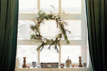 Beautiful Christmas wreath hanging on the window at light loft interiorの写真素材