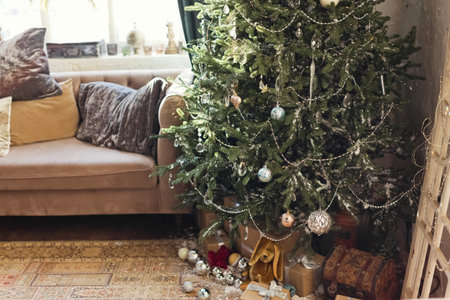 Living room with Christmas tree, sofa with pillows and beautiful wreath on the window