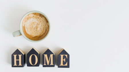 Cup with coffee and black wooden home decoration on a white table background, copy spaceの写真素材