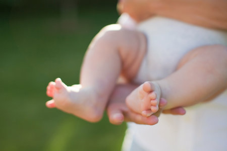Man in white clothes holding little baby outdoors at sunset light. Fatherhood conceptの写真素材