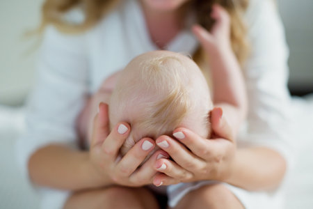 Mother and little infant baby. Caucasian woman holding baby headの写真素材
