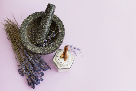 Lavender sugar on purple background, copy space. Granite mortar and pestle with flowers lavender, bouquet of dry lavender and glass jar with lavender sugarの写真素材