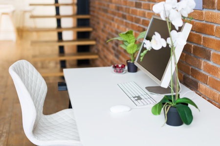 Workspace with computer on the table near brown brick wall, copy spaceの写真素材