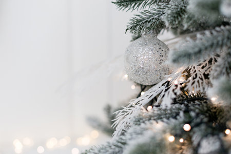 Christmas tree with silver, white decorations and cozy lights. Christmas concept with copy space, place for textの写真素材