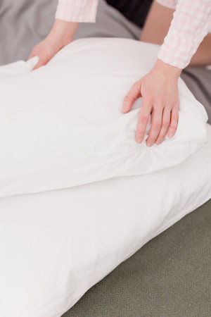 A woman in pink pajama changes bed linen