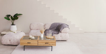 Bright interior with sofa, wooden table, plant and stairsの写真素材