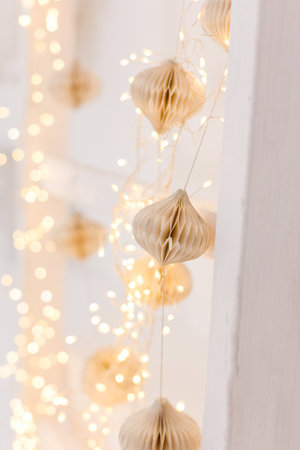 Christmas paper garland and lights hanging on a wallの写真素材
