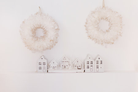 White Christmas house decorations and feather wreaths on a white wallの写真素材