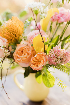 Beautiful bouquet in yellow pitcher vase