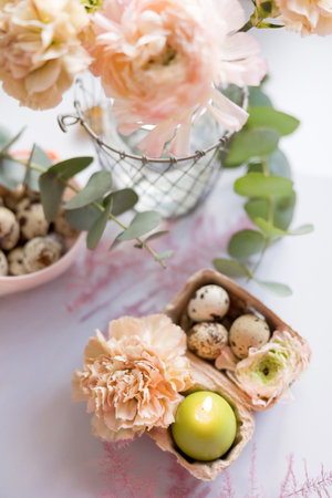 Easter concept, quail eggs, flowers and burning candle on a purple backgroundの写真素材