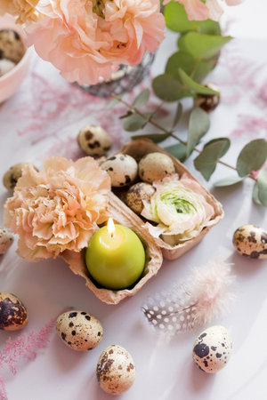 Easter concept, quail eggs, flowers and candle on a purple backgroundの写真素材