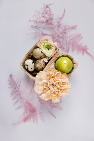 Easter concept, quail eggs, flowers and candle on a white backgroundの写真素材