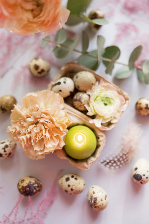 Easter concept, quail eggs, flowers and burning candle on a purple backgroundの写真素材