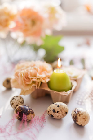 Easter concept, quail eggs, flowers and burning candle on a purple backgroundの写真素材