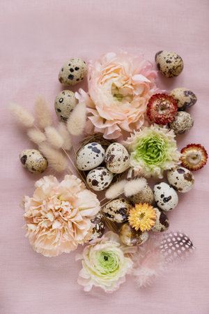 Quail eggs, flowers and feather on a pink cloth background, copy spaceの写真素材