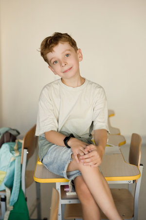 Caucasian boy sits in classroom, back to school