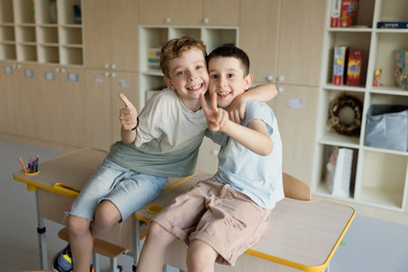 Smiling caucasian boys sits in classroom, back to schoolの写真素材