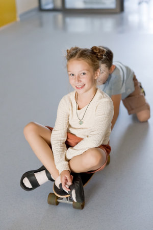 Happy kids on skateboard at school hallway, having funの写真素材
