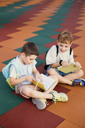 Boys with books sitting outdoors, back to schoolの写真素材