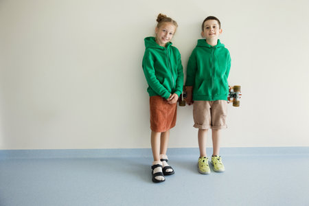 Kids in green hoodie near white wall background, copy spaceの写真素材