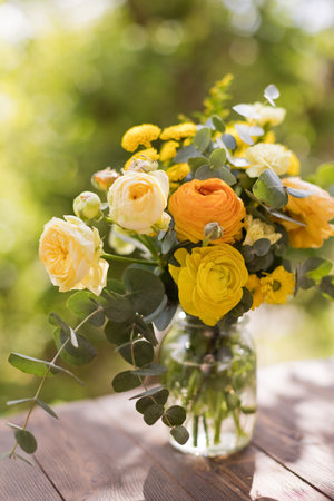 Yellow bouquet with roses,ranunculus,chrysanthemums and eucalyptusの写真素材