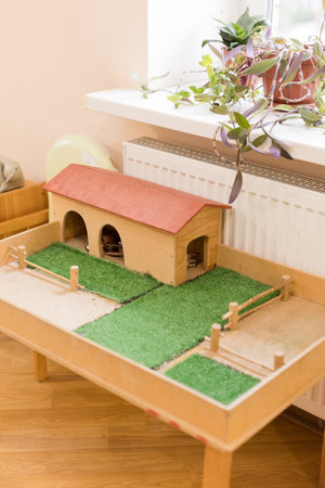 Miniature wooden farm model with grass, fences, and a barnの写真素材