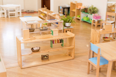 Montessori classroom with wooden shelves, educational toys, and learning materials.の写真素材