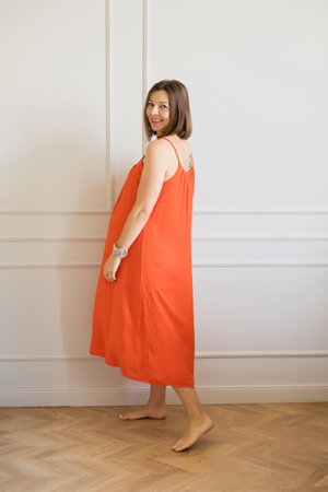 Elegant pregnant woman in orange dress, radiant and sereneの写真素材