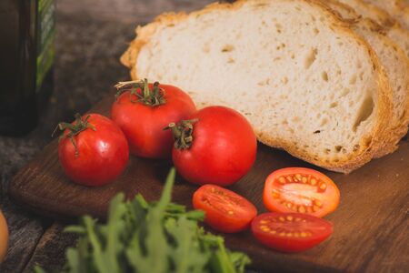 red tomatoes and bread on a board. ingredients for breakfastの写真素材
