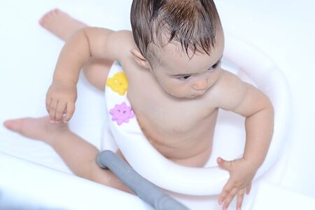 washing and playing baby in white bathの写真素材