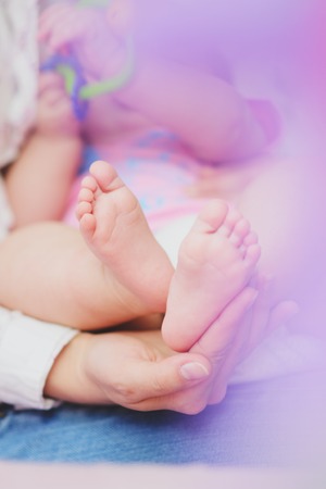 Baby legs. Legs newborn in parents hand.の写真素材