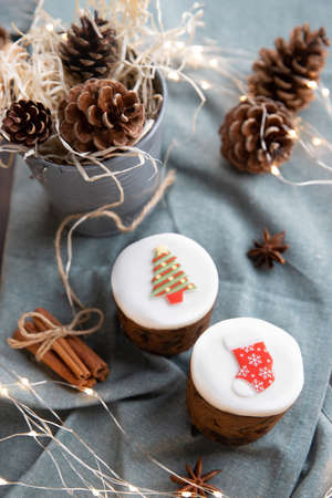 Christmas decorated sweet pastry on teal background, pine cones, cinnamon and anise stars as eco decorationの写真素材