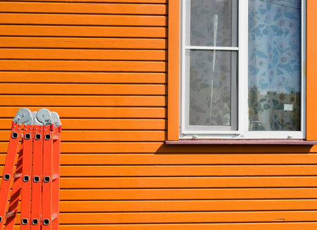 A country house after painting. Folding staircase on the background of a freshly painted wooden house. high quality photoの写真素材