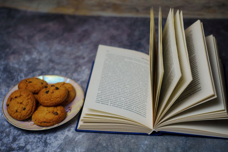 Open book next to a plate of cookies. High quality photo