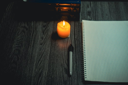 Large notebook and black marker in candlelight on the wooden table. High quality photo