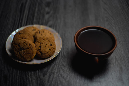 Mug of coffee and plate with cookies on wooden table. High quality photo