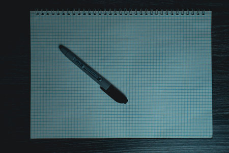 Large notebook and black marker in candlelight on the wooden table. High quality photo