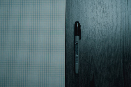 Large notebook and black marker in candlelight on the wooden table. High quality photo