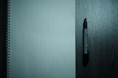 Large notebook and black marker in candlelight on the wooden table. High quality photo