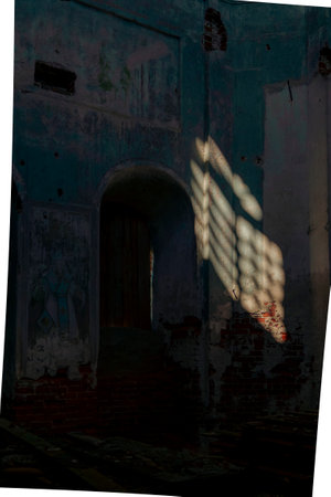 Light and shadows cast through a window, illuminating the weathered walls and brickwork inside an abandoned church.の写真素材