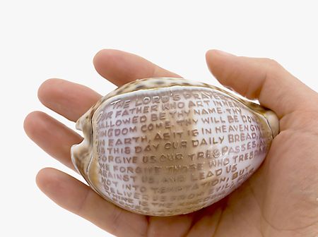 Cockleshell on which prayer in hand isolated on whiteの写真素材