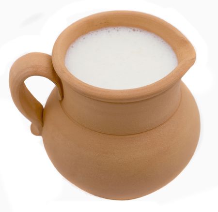 Milk in clay jug is isolated on white backgroundの写真素材