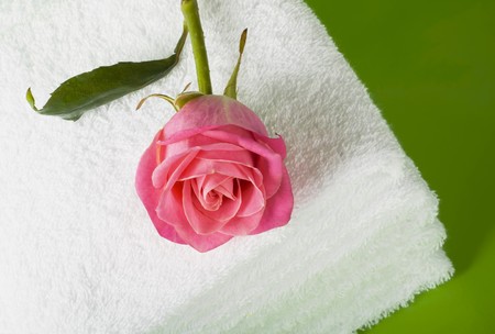 Pile white towels on green background and roseの写真素材