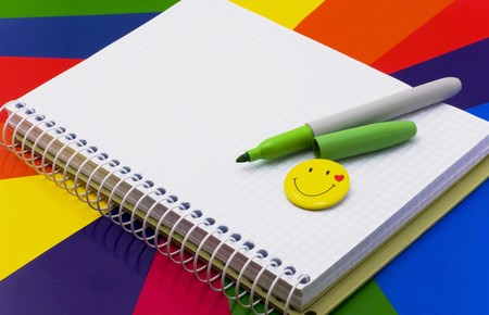 notebook, felt-tip pen of green  badge-smile lie on colour paperの写真素材