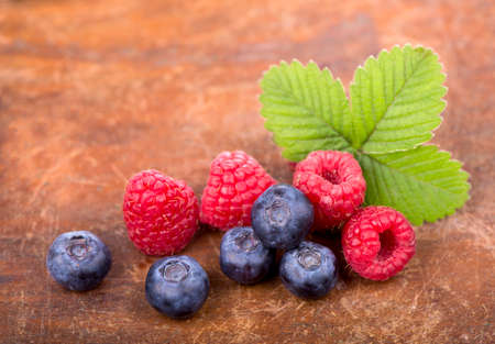 Berries raspberries  blackberries and mint on a wooden backgroundの写真素材